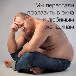 Мужчина сидит, обняв колени, выглядит задумчивым
