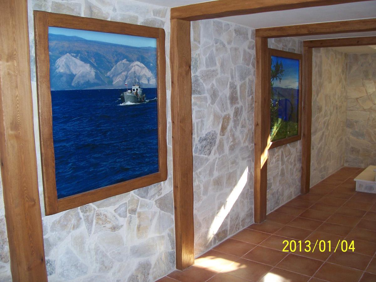 Коридор с каменными стенами и картинами моря