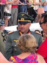 Мужчина в военной форме общается с женщиной в ярком наряде