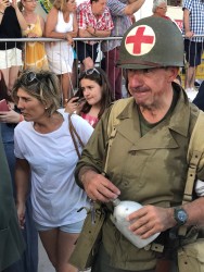 Человек в военной форме с красным крестом и флягой