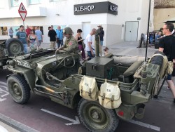 Военный джип с солдатом на улице, люди вокруг