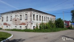 Старое здание с обветшалой кирпичной стеной и окнами