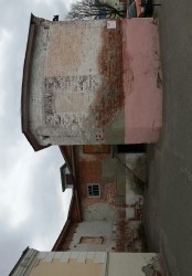 Старое здание с кирпичной и оштукатуренной стенами
