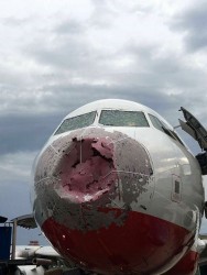 Поврежденный нос самолета на фоне облачного неба