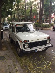 Старая белая машина на улице среди пальм