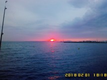 Закат над морем с облаками и рыболовной удочкой