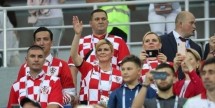Люди в фанатской одежде на трибунах стадиона