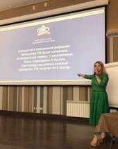 Женщина в зеленом платье выступает на семинаре о пенсионной реформе