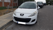 Белый автомобиль припаркован на улице рядом с домом