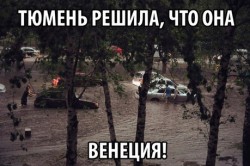 Затопленные улицы города, люди в воде и автомобили
