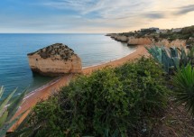 Пляж с скалами и спокойным морем на закате