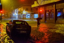 Ливень на улице, затопленная дорога и человек с зонтом