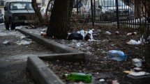 Мусор на тротуаре рядом с деревом и автомобилями