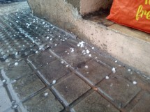 Лужи и градины на тротуаре после дождя