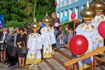 Люди в костюмах с золотыми головными уборами на празднике