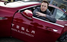 Человек в автомобиле Tesla с надписью 100% электрический