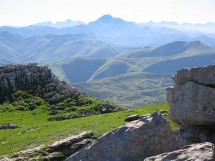 Горный пейзаж с зелеными холмами и скалами
