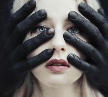 Лицо девушки, окруженное черными руками