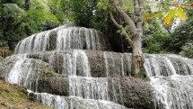Каскадный водопад среди зелёных деревьев