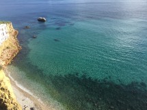Чистая вода у береговой линии с камнями и пляжем