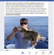 Человек в полосатой футболке держит рыбу на фоне моря