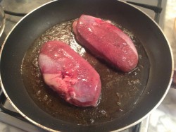 Два куска мяса жарятся на сковороде