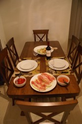 Стол с блюдами: салат, мясо, соусы и вино