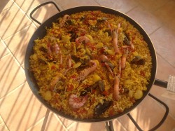 Паэлья с морепродуктами и овощами в сковороде