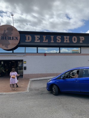 Вход в магазин Delishop, женщина с коляской — CostaSpain.net Вход в магазин Delishop, женщина с коляской