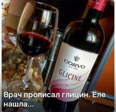 Красное вино в бокале и бутылка на столе