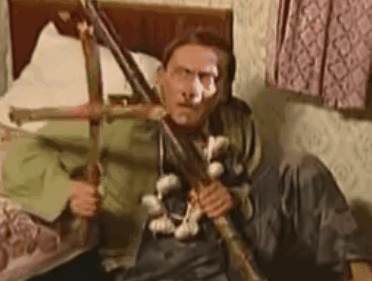 Человек с крестом и палкой в комнате