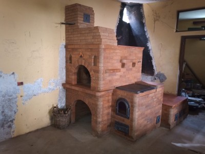 Кирпичная печь с плитой и арками в комнате