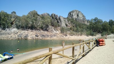 Песчаный пляж у водоема с каменистыми берегами в Испании
