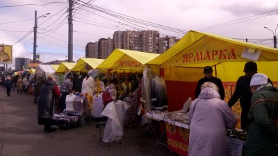 Ярмарка с желтыми палатками и покупателями