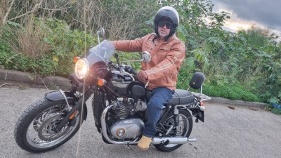 Мужчина на мотоцикле Triumph в кожаной куртке