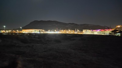 Ночной пейзаж с горами и освещённой набережной в Испании