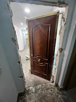 Дверь в процессе установки, вокруг видны следы ремонта