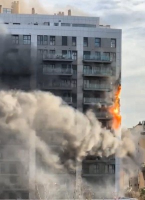Пожар на верхних этажах многоэтажного здания, клубы дыма