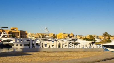 Надпись "#ElGouna State Of Mind" на набережной с яхтами