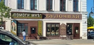 Вывески магазинов на улице, люди и автомобили в Испании