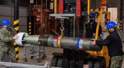 Работники перемещают боеприпасы с помощью погрузчика