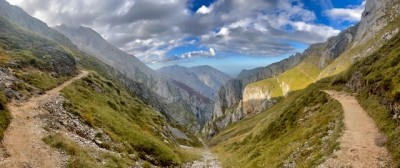 Горная долина с тропами и облачным небом