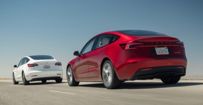 Два автомобиля Tesla на дороге, один красный, другой белый