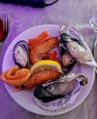 Ассорти из морепродуктов с лимоном на тарелке в Испании