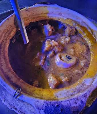 Горячее блюдо в глиняной посуде с мясом и соусом