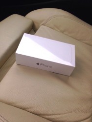 Коробка от iPhone на кожаном сиденье автомобиля