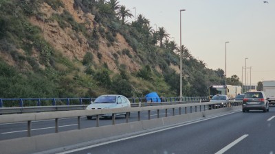 Дорога с движущимися автомобилями и зелеными холмами