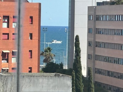 Морской пейзаж между зданиями, виден катер в Испании