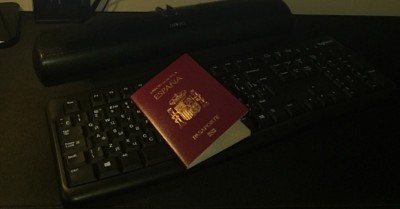 Красный паспорт Испании на черной клавиатуре
