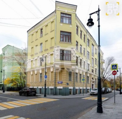Угол здания с декоративными элементами и уличными фонарями